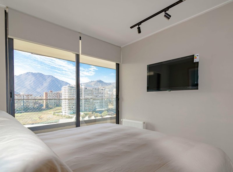 Cozy bedroom interior with a stunning mountain view and wall-mounted TV.