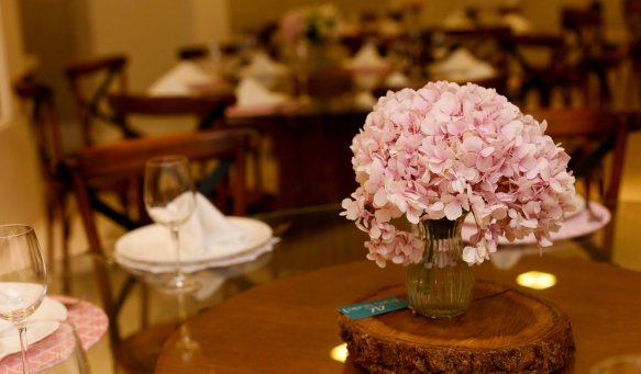 Charming pink flower arrangement in vase on a set dining table, perfect for decor inspiration.